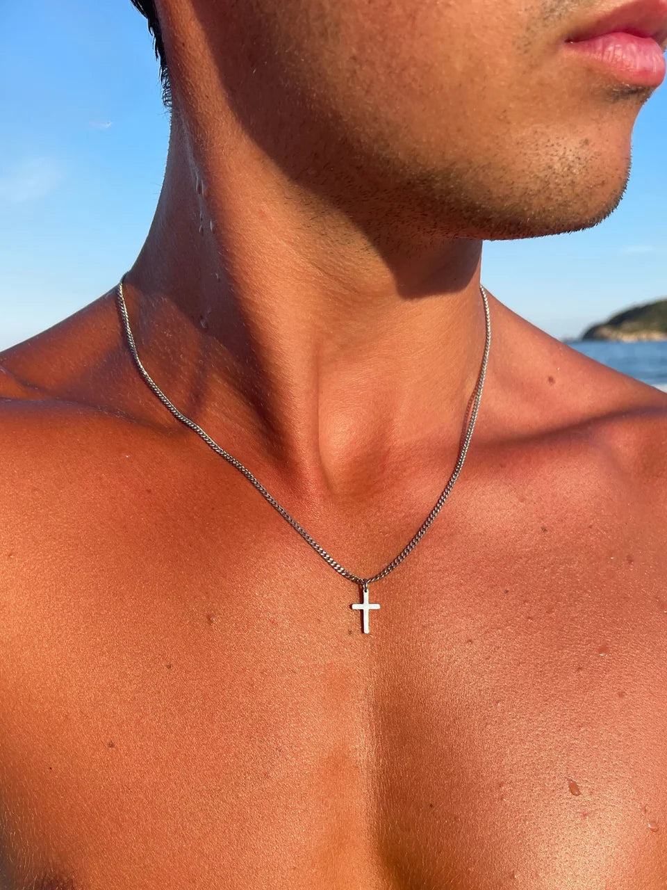 Man wearing the stainless steel cross necklace at the beach